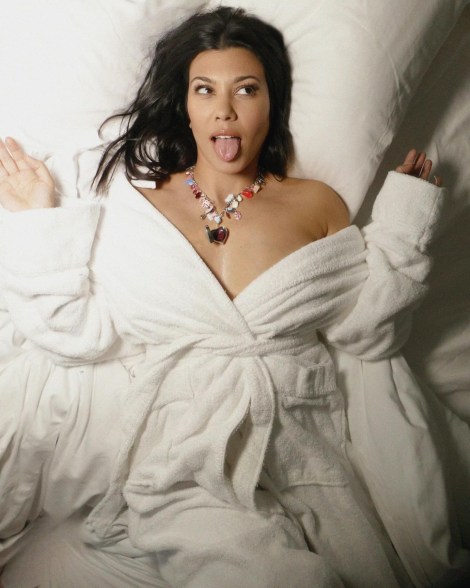 kourtney kardashian lying in bed in a robe